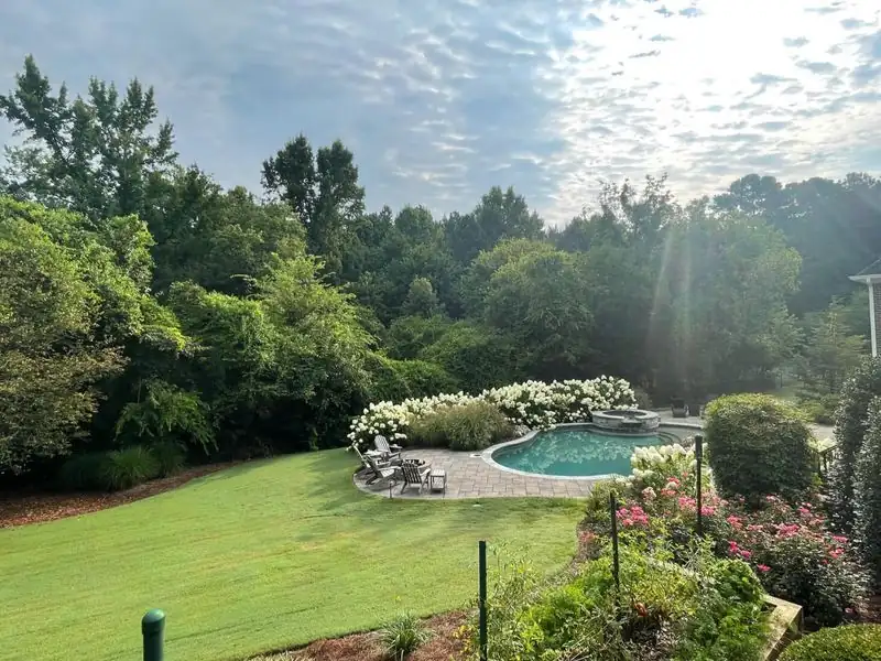 Backyard lawn maintenance near pool area — Charlottesville VA